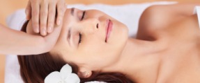 Beautiful fresh woman having facial massage in spa centre